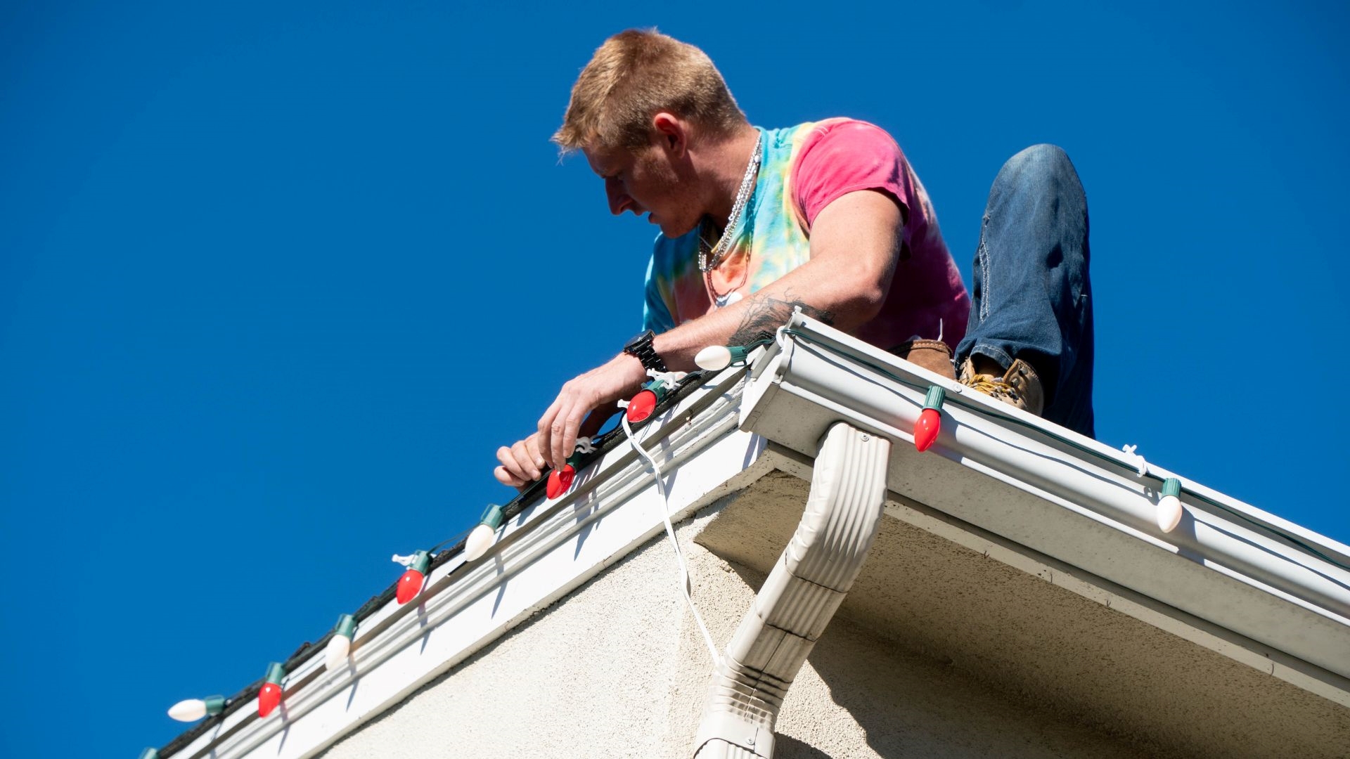 Expert General Suds Pressure Washing tech installating holiday lights on Columbia home's roof.